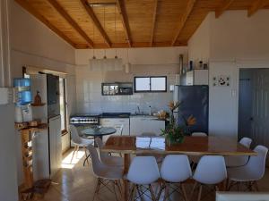 a kitchen with a table and some white appliances at Casa Estela del Mar in Pelluhue