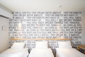 a bedroom with a bed with a wall with a heart mural at U-Hotel Takadanobaba in Tokyo