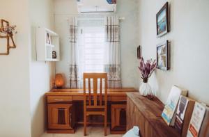 a desk in a room with a chair and a table at ngaunhien's house - Homestay in Thôn Dư Khánh