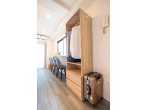 Habitación con armario y TV. en ZAITO Tokyo Kinshicho Economy Inn 宅东东京横川1民宿, en Tokio