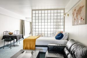 a bedroom with a bed and a couch and a table at The Beachcomber Hotel in Nelson