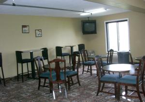 a dining room with tables and chairs and a tv at Norwood Inn and Suites - Roseville in Roseville
