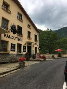 un edificio con un letrero al lado de una calle en Hôtel Le Val Du Tech, en Prats-de-Mollo-la-Preste