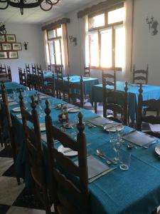 a dining room with tables and chairs with blue tablecloths at Hôtel Le Val Du Tech in Prats-de-Mollo-la-Preste