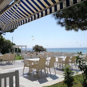 una fila de mesas y sillas con el océano en el fondo en Iris Hotel en Çanakkale