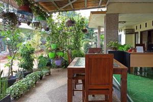 une terrasse avec une table, des chaises et des plantes en pot dans l'établissement RedDoorz near Taman Merdeka Metro Lampung, à Lampung
