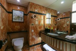 uma casa de banho com um WC, um lavatório e um espelho. em Diamond Hotel Philippines em Manila