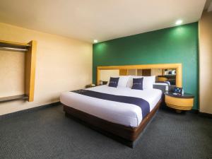 a bedroom with a large bed with a green wall at Capital O Autoparador Del Valle,Centro Industrial Tlalnepantla in Mexico City