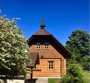 a large wooden building with a tower on top of it at Šumavská roubenka in Vacov