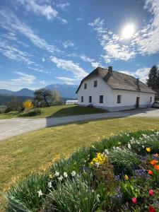 ein weißes Haus mit einem Blumenfeld in der Unterkunft Ferienhaus Karl in Bleiburg