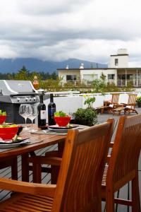 a wooden table with wine bottles and glasses on a patio at Rosellen Suites at Stanley Park in Vancouver