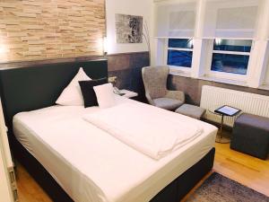 a bedroom with a bed and a chair and windows at Schlosshotel Landstuhl in Landstuhl +30 photos