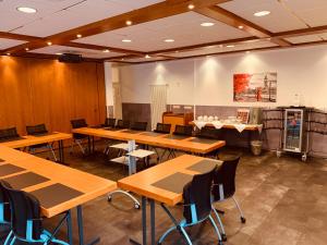 a room with wooden tables and chairs and a kitchen at Schlosshotel Landstuhl in Landstuhl