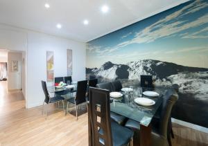 a dining room with a table and a mountain mural at Apartamentos Day Madrid SILVA Centro Gran Via Sol Malasaña in Madrid