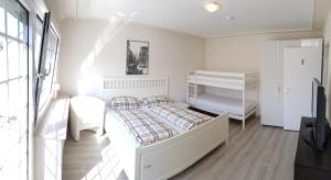 a white bedroom with a bed and a dresser at Ferienhaus Anja Bad Pyrmont in Bad Pyrmont