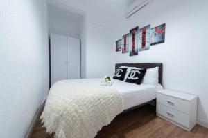 sypialnia z łóżkiem z białą narzutą w obiekcie Apartamentos Day Madrid SILVA Centro Gran Via Sol Malasaña w Madrycie