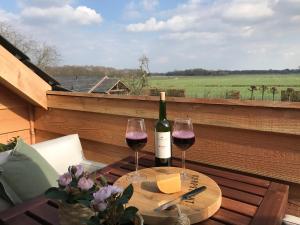 Vijverhoef في Ulicoten: زجاجة من النبيذ وكأسين على الطاولة