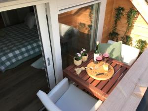 Vijverhoef في Ulicoten: طاولة مع زجاجتين من النبيذ والزهور على شرفة