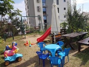a playground with a table and chairs and a slide at Apartmani Becici in Bečići