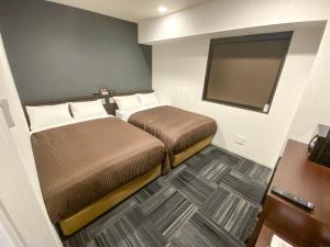 Un pat sau paturi într-o cameră la HOTEL LiVEMAX Okayama Kurashiki Ekimae