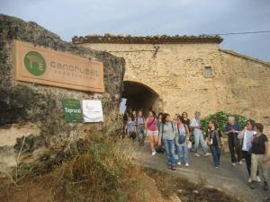 um grupo de pessoas andando em frente a um edifício em Can Cruset agroturisme em Torrellas de Foix