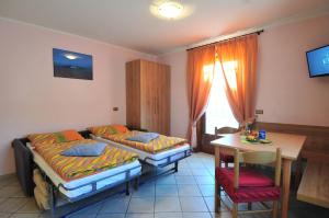 a room with two beds and a table and a tableablish at Casa Fiorella in Livigno