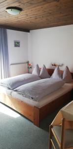 a large bed in a bedroom with a wooden ceiling at Sonneck Pension in Pfarrwerfen