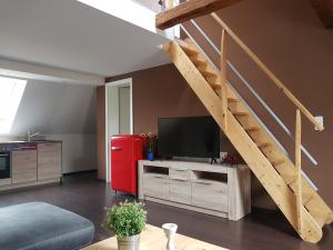 a living room with a television and a staircase at Pension Zechliner Hof in Flecken Zechlin