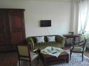 a living room with a green couch and chairs at Gästehaus Flair in Mettlach