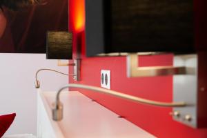 a red wall with a desk with a lamp at Corps et graphi(qu)es in Périgueux +24 photos