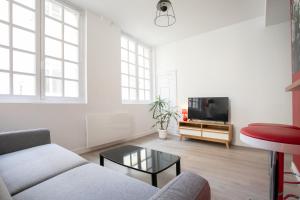 uma sala de estar com um sofá e uma televisão em Corps et graphi(qu)es em Périgueux