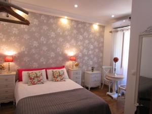 リスボンにあるSweet Suites Guesthouse close to famous Avenue Libertyのベッドルーム1室(ベッド1台付)、花の壁
