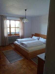 Schlafzimmer mit einem Bett und einem Fenster in der Unterkunft Schneiderhof in Steinbach
