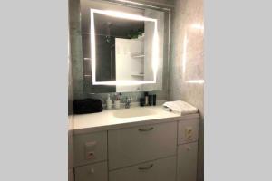 a bathroom with a sink and a mirror at Ruim 3 slaapkamerappartement vlakbij het strand in Koksijde