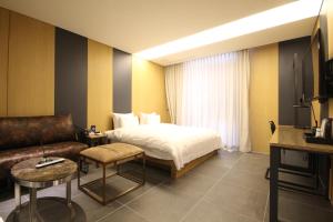 une chambre d'hôtel avec un lit et un canapé dans l'établissement Hotel Eco stay, à Jeonju