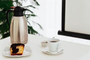 a tea kettle and a piece of cake and a cup of coffee at Pravi Hotel in Eleftheroúpolis