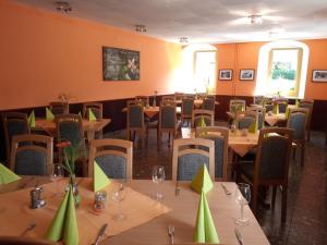 un restaurant avec des tables, des chaises et des serviettes vertes dans l'établissement Pension Sommerfrische, à Ehrenfriedersdorf