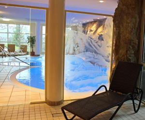 a bench in a lobby with a mural of a mountain at Hotel Berghof in Pfronten