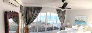 a bedroom with a large window with a view of the ocean at Sorgente 304 with Inverter in Umdloti