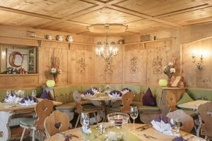 a restaurant with tables and chairs and a chandelier at Hotel Berghof in Pfronten
