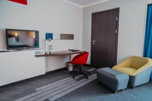 a room with a desk and a chair and a tv at Piter Inn in Petrozavodsk