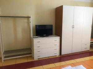 a bedroom with a tv and a dresser with a television at Bnbook-Borromeo 2 in Rho