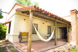 un patio con una hamaca frente a una casa en Golden Lodge en Paso de la Patria