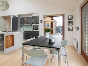 cocina y comedor con mesa negra y sillas en 6 person holiday home in Hj rring, en Lønstrup