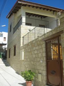 - un bâtiment avec un balcon sur le côté dans l'établissement Omodos Katoi Holiday Homes, à Omodos