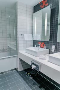 uma casa de banho com 2 lavatórios e um espelho em Piter Inn em Petrozavodsk