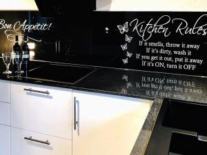 a kitchen counter with a kitchen rules wall sticker at 12 person holiday home in V ggerl se in Marielyst