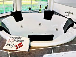 a white bath tub in a bathroom with a sign at 12 person holiday home in V ggerl se in Marielyst