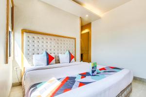 ボーパールにあるFabHotel Naman Palaceのベッドルーム1室(ベッド2台、大型ヘッドボード付)