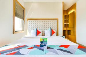 a bedroom with a large bed with a colorful bedspread at FabHotel Naman Palace in Bhopal